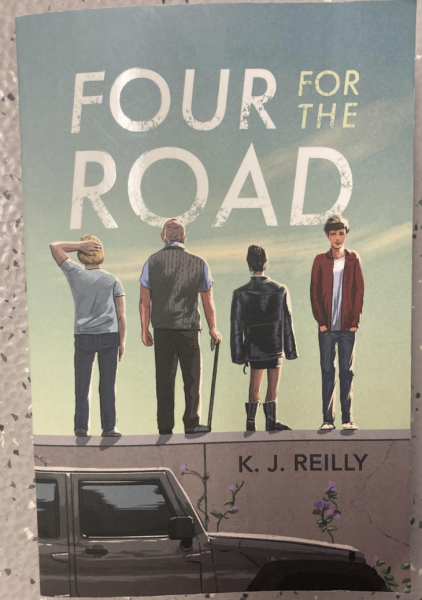 The cover of Four for the Road by K. J. Reilly depicts Will, Henry, Sloane, and Asher standing on a stone wall. 
